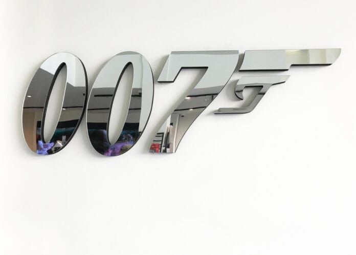 Metallic 007 logo on a white wall, reflecting its surroundings.