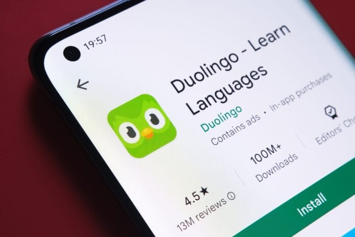 A close-up of a smartphone screen displaying the Duolingo language learning app on the Google Play Store, highlighting its rating and number of downloads.