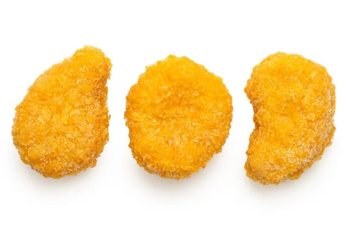 Three golden-brown chicken nuggets on a white background.